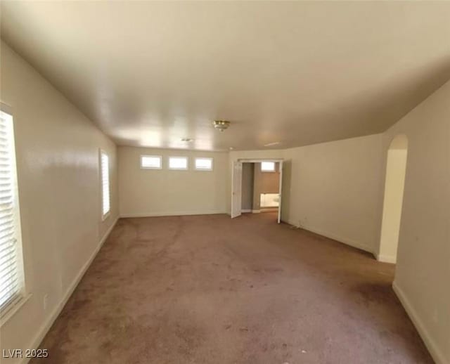 basement featuring baseboards and light colored carpet