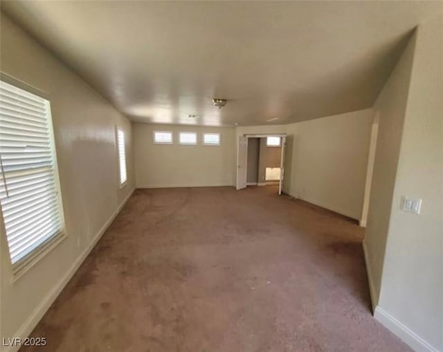 carpeted spare room featuring baseboards