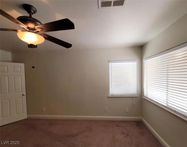 unfurnished room with a wealth of natural light, visible vents, light colored carpet, and a ceiling fan