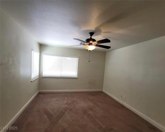 carpeted spare room with ceiling fan and baseboards