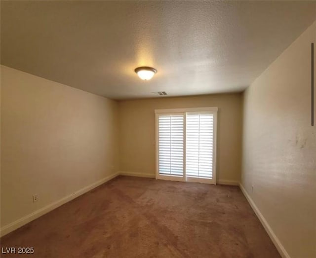 carpeted spare room with baseboards and visible vents