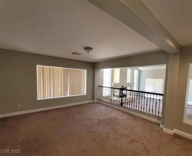 empty room featuring visible vents, baseboards, and carpet floors