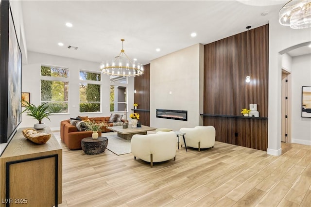 800 Jody Brook Ct, Las Vegas, NV 89145 - living area with a glass covered fireplace, arched walkways, light wood-style floors, a chandelier, and recessed lighting