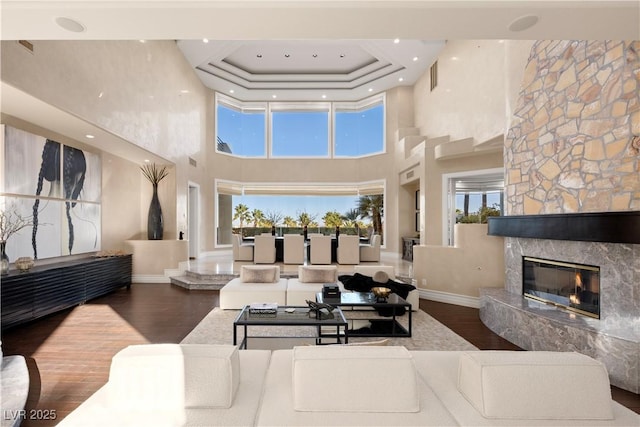 5020 Spanish Heights Dr, Las Vegas, NV 89148 - living room with a towering ceiling, wood finished floors, baseboards, a fireplace, and healthy amount of natural light