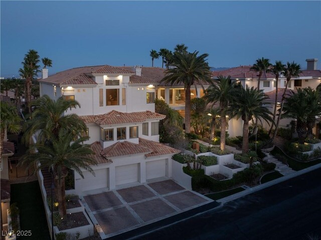 5020 Spanish Heights Dr, Las Vegas, NV 89148 - mediterranean / spanish-style home featuring a tiled roof, driveway, stucco siding, and an attached garage