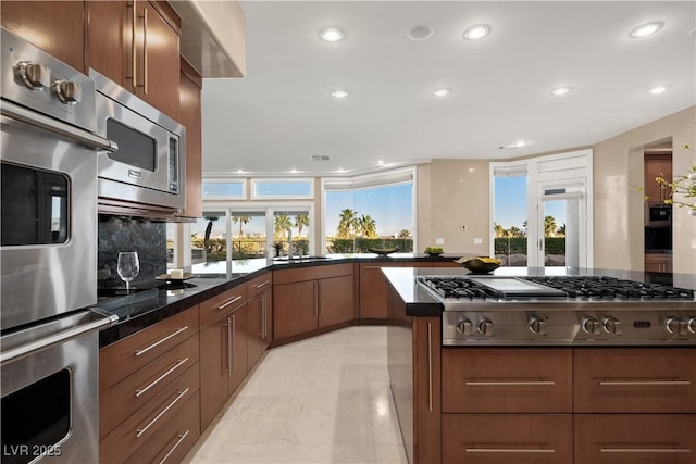 5020 Spanish Heights Dr, Las Vegas, NV 89148 - kitchen with stainless steel appliances, recessed lighting, decorative backsplash, brown cabinets, and a sink
