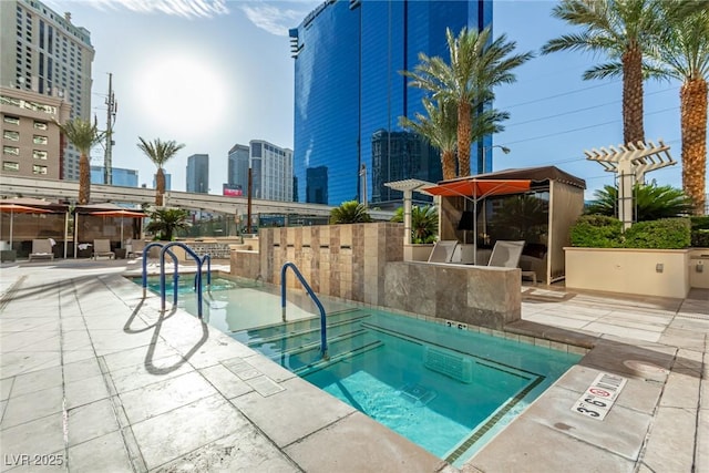 145 E Harmon Ave Unit 2019, Las Vegas, NV 89109 - view of swimming pool featuring a patio area, a view of city, and a pergola