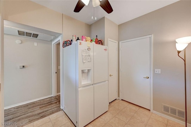 kitchen featuring visible vents, ceiling fan, and white fridge with ice dispenser