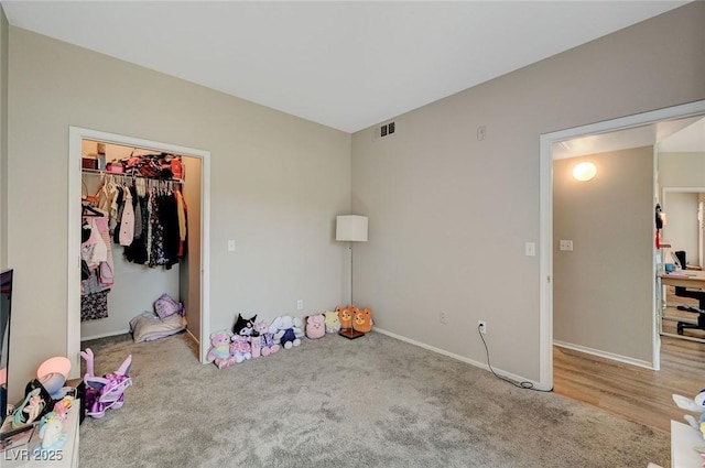 unfurnished bedroom with visible vents, baseboards, a closet, a spacious closet, and carpet floors