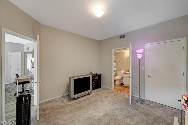 bedroom with visible vents, baseboards, ensuite bathroom, and carpet