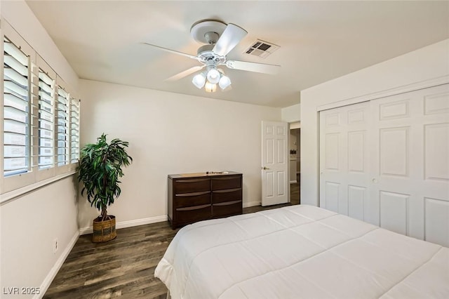 bedroom with a ceiling fan, wood finished floors, a closet, baseboards, and visible vents