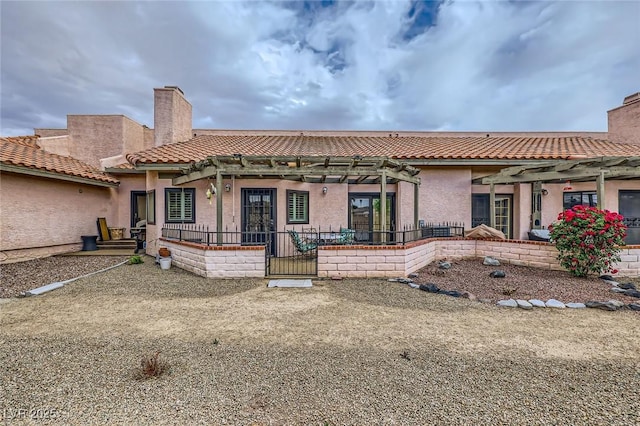 back of property featuring a pergola, a chimney, and stucco siding