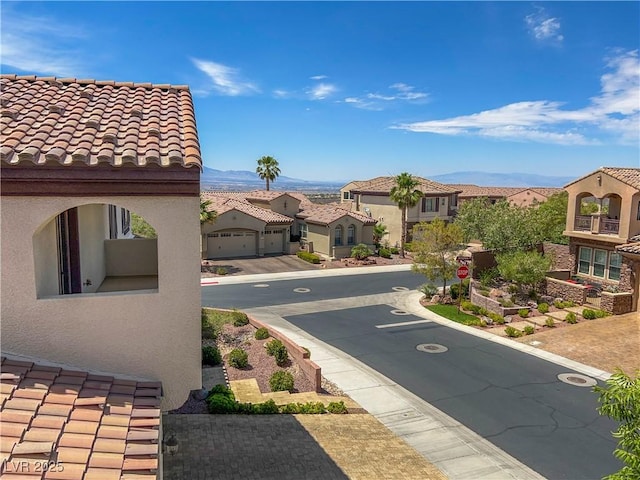 2805 Proust Ct, Henderson, NV 89044 - view of asphalt street featuring a residential view, traffic signs, a mountain view, and curbs