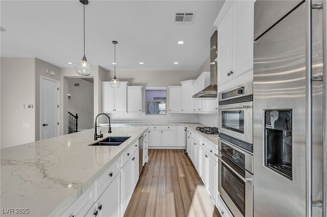 2805 Proust Ct, Henderson, NV 89044 - kitchen featuring appliances with stainless steel finishes, light wood-type flooring, tasteful backsplash, recessed lighting, and light stone countertops