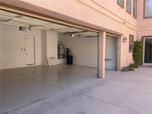 2805 Proust Ct, Henderson, NV 89044 - garage featuring secured water heater, driveway, and a garage door opener