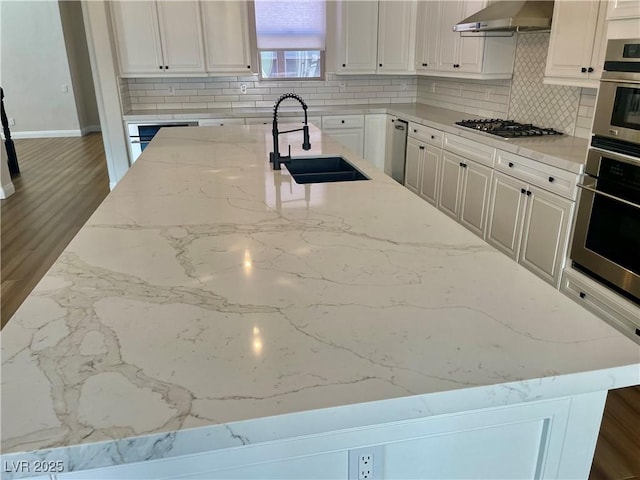 2805 Proust Ct, Henderson, NV 89044 - kitchen featuring stainless steel appliances, wall chimney range hood, tasteful backsplash, and light stone countertops