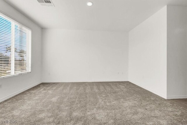 unfurnished room featuring visible vents, plenty of natural light, and carpet flooring