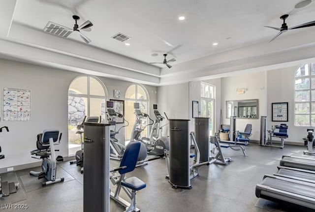 workout area with recessed lighting, a tray ceiling, visible vents, baseboards, and ceiling fan
