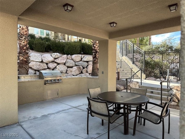 view of patio / terrace featuring a grill, outdoor dining space, stairway, and area for grilling