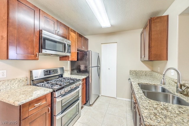 2120 Ramrod Ave Unit 2216, Henderson, NV 89014 - kitchen with a textured ceiling, appliances with stainless steel finishes, light stone counters, a sink, and baseboards