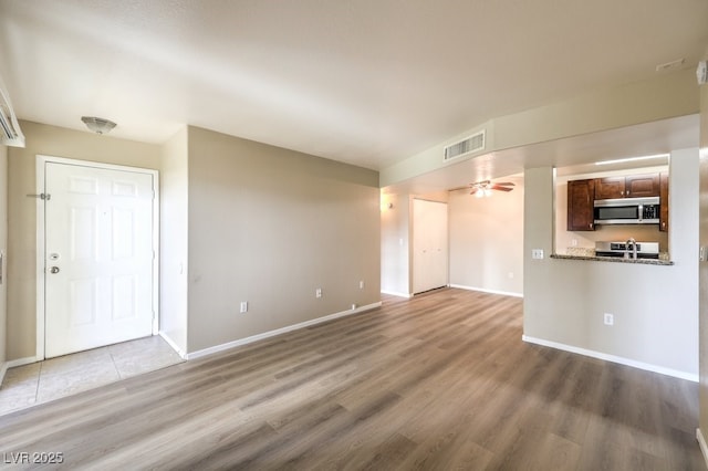 2120 Ramrod Ave Unit 2216, Henderson, NV 89014 - unfurnished living room with visible vents, baseboards, a ceiling fan, and wood finished floors