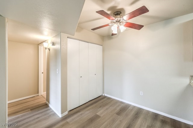 2120 Ramrod Ave Unit 2216, Henderson, NV 89014 - unfurnished bedroom with wood finished floors, a closet, a ceiling fan, and baseboards