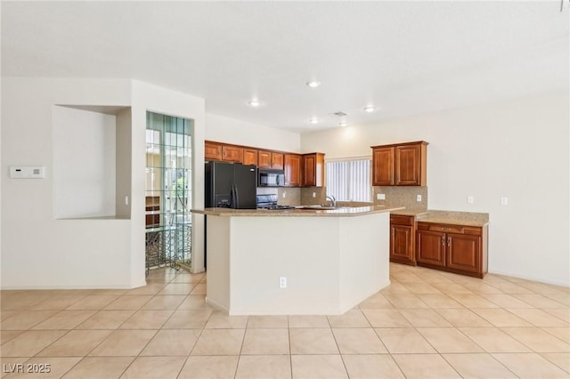 3029 Paseo Hills Way, Henderson, NV 89052 - kitchen featuring black appliances, brown cabinetry, a sink, a kitchen island with sink, and tasteful backsplash