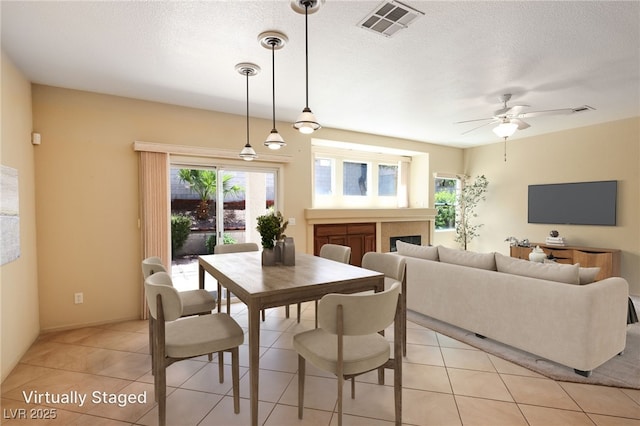 3029 Paseo Hills Way, Henderson, NV 89052 - dining space with a ceiling fan, light tile patterned floors, a textured ceiling, and a fireplace
