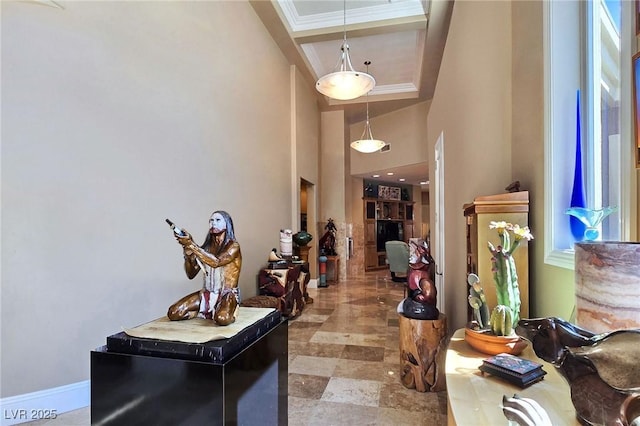 foyer featuring a towering ceiling and baseboards