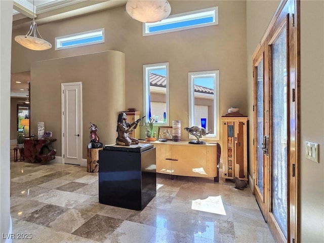 foyer with a towering ceiling and baseboards