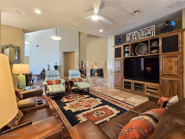 living room with a fireplace and ceiling fan