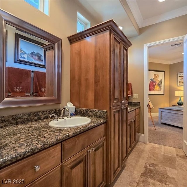 bathroom with ornamental molding, vanity, and baseboards