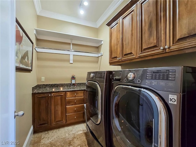 laundry area featuring cabinet space, ornamental molding, washing machine and dryer, and baseboards