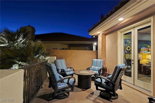 patio at night with french doors and an outdoor fire pit