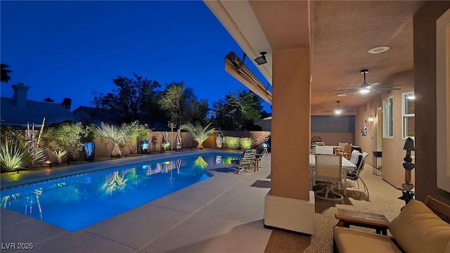 pool at twilight with a fenced backyard, a patio, a ceiling fan, outdoor dining space, and an outdoor hangout area