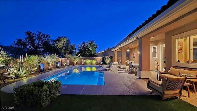 pool at twilight featuring a patio and a fenced backyard