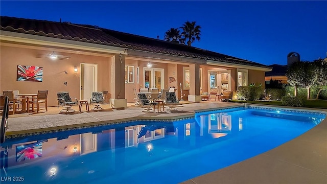 pool at twilight with a patio area, an outdoor pool, and outdoor dining space