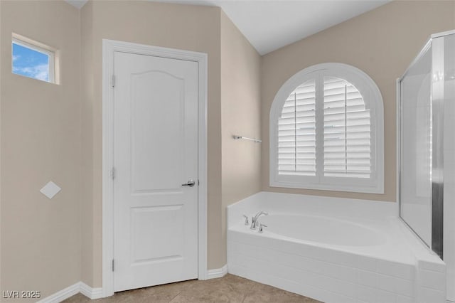bathroom with tile patterned floors, baseboards, and a garden tub