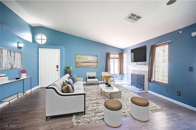 7103 Shadow Crest Dr, Las Vegas, NV 89119 - living area featuring vaulted ceiling, wood finished floors, a tiled fireplace, and baseboards