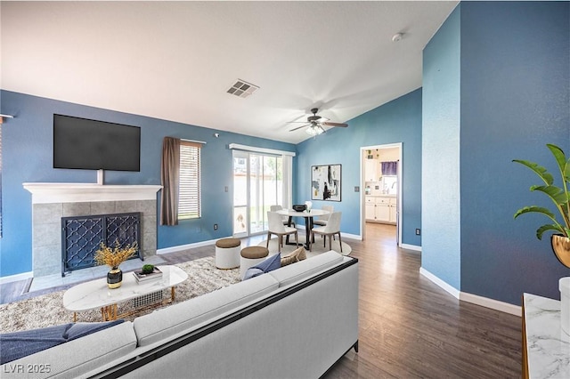7103 Shadow Crest Dr, Las Vegas, NV 89119 - living room with lofted ceiling, wood finished floors, ceiling fan, baseboards, and a tiled fireplace