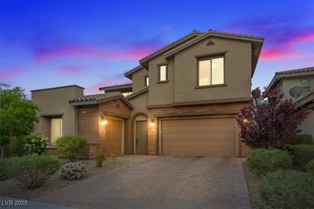 342 Molinetto St, Las Vegas, NV 89138 - view of front facade featuring stucco siding, decorative driveway, brick siding, a tile roof, and a garage
