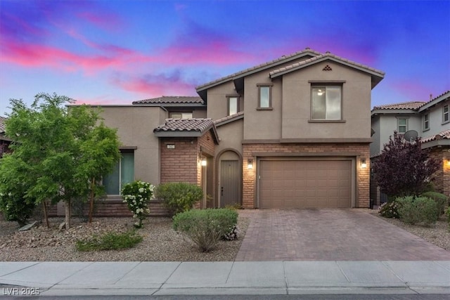 342 Molinetto St, Las Vegas, NV 89138 - mediterranean / spanish-style house with a tiled roof, an attached garage, stucco siding, brick siding, and decorative driveway
