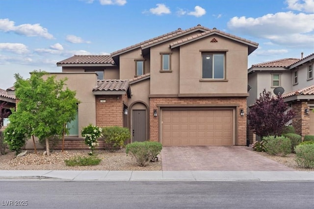 342 Molinetto St, Las Vegas, NV 89138 - mediterranean / spanish-style home featuring a tiled roof, stucco siding, decorative driveway, brick siding, and an attached garage
