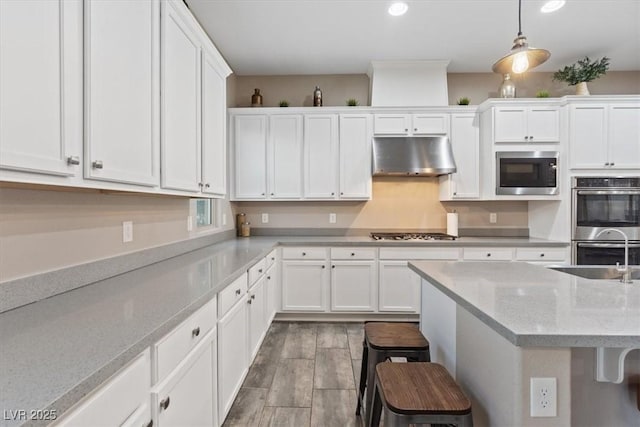 342 Molinetto St, Las Vegas, NV 89138 - kitchen featuring a sink, appliances with stainless steel finishes, a breakfast bar area, and under cabinet range hood