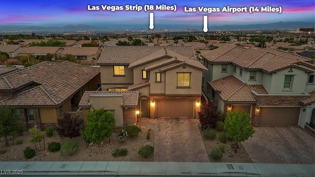 342 Molinetto St, Las Vegas, NV 89138 - view of front of house featuring a tiled roof, a garage, stucco siding, a residential view, and driveway