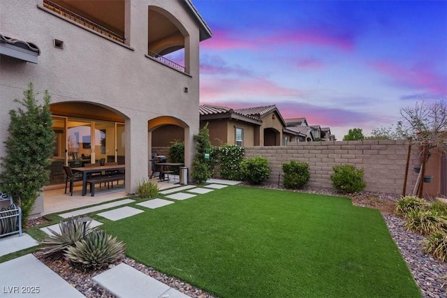 342 Molinetto St, Las Vegas, NV 89138 - yard at dusk with a patio, fence, and a balcony