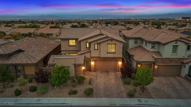 342 Molinetto St, Las Vegas, NV 89138 - mediterranean / spanish house featuring an attached garage, a tiled roof, driveway, and stucco siding