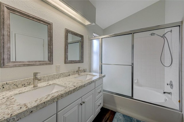 full bathroom featuring vaulted ceiling, a sink, enclosed tub / shower combo, and wood finished floors