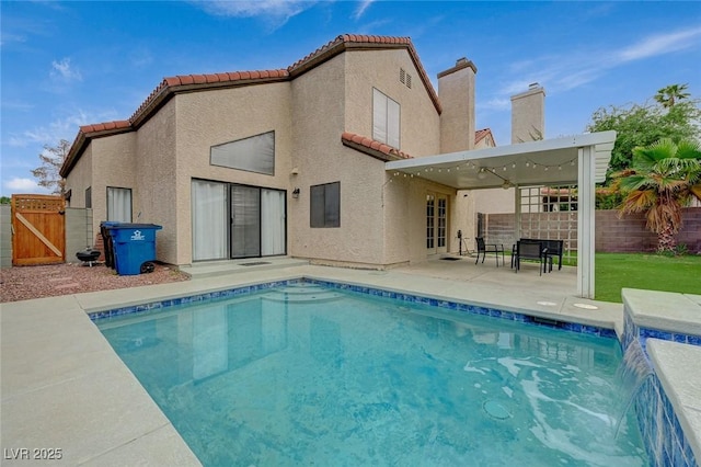 back of property with a tile roof, fence, and a patio