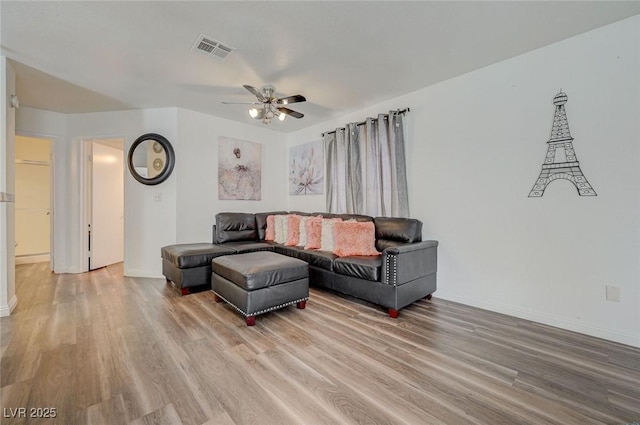 living area featuring visible vents, ceiling fan, baseboards, and light wood-style flooring